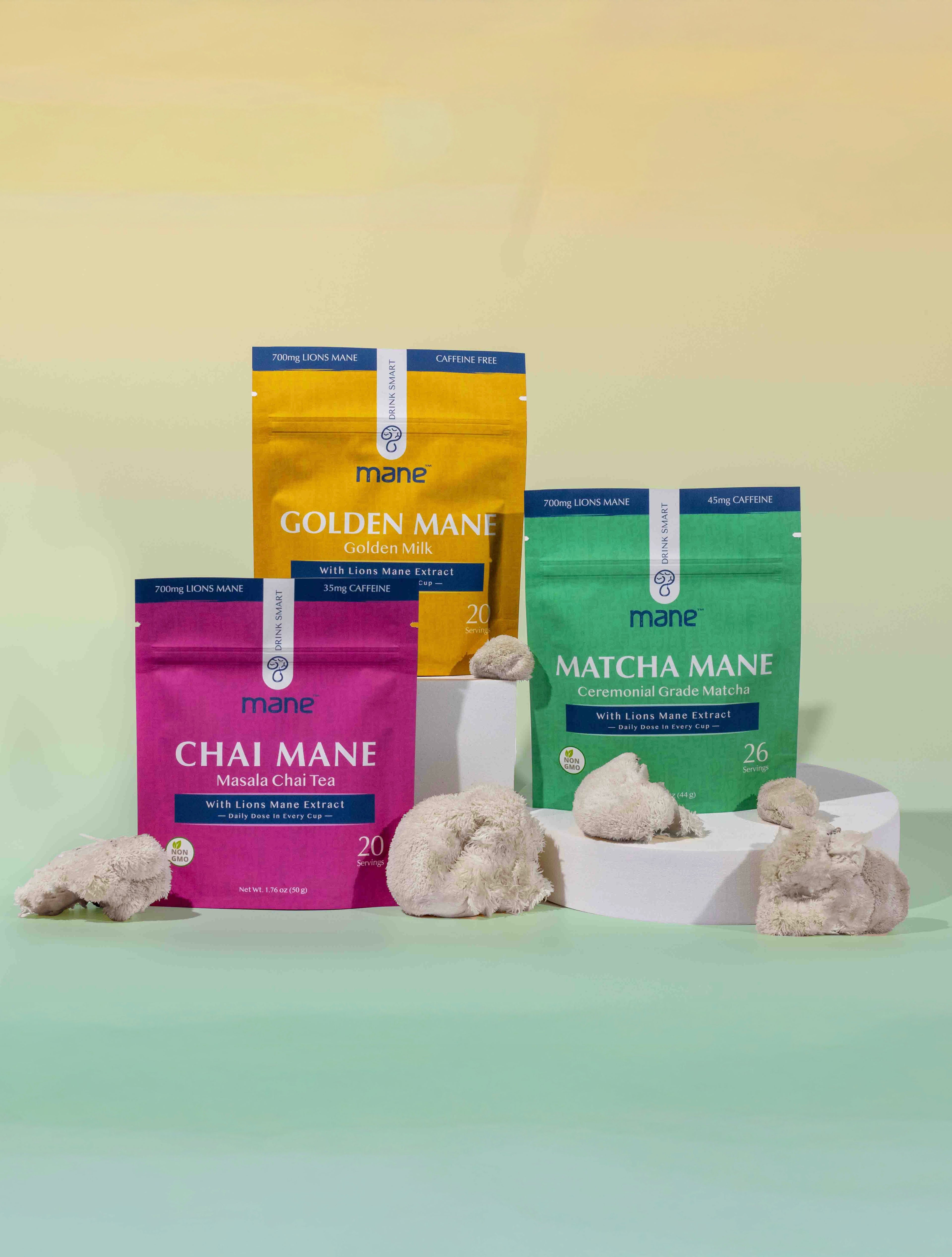three packages of chai, golden milk and matcha, stacked with lions mane and yellow and green gradient background